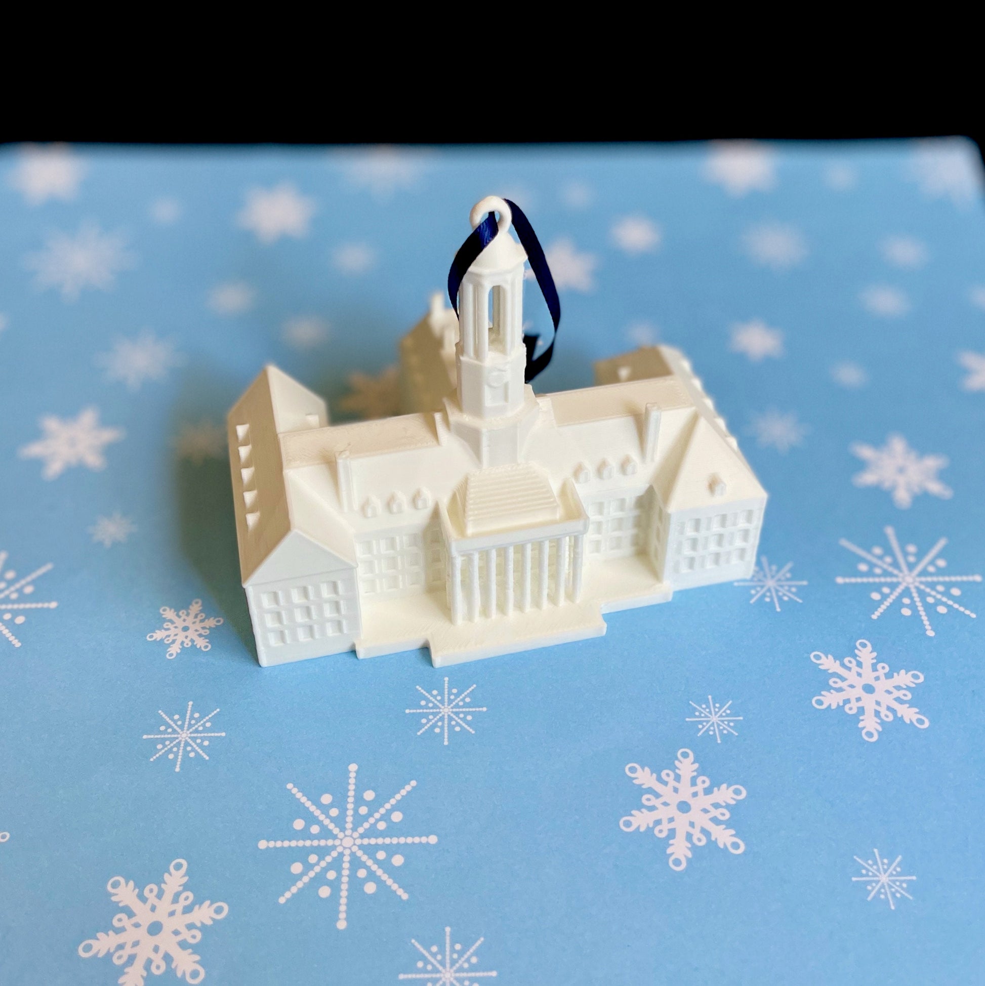 The Penn State Christmas decoration for a college student, shown against a blue holiday background.