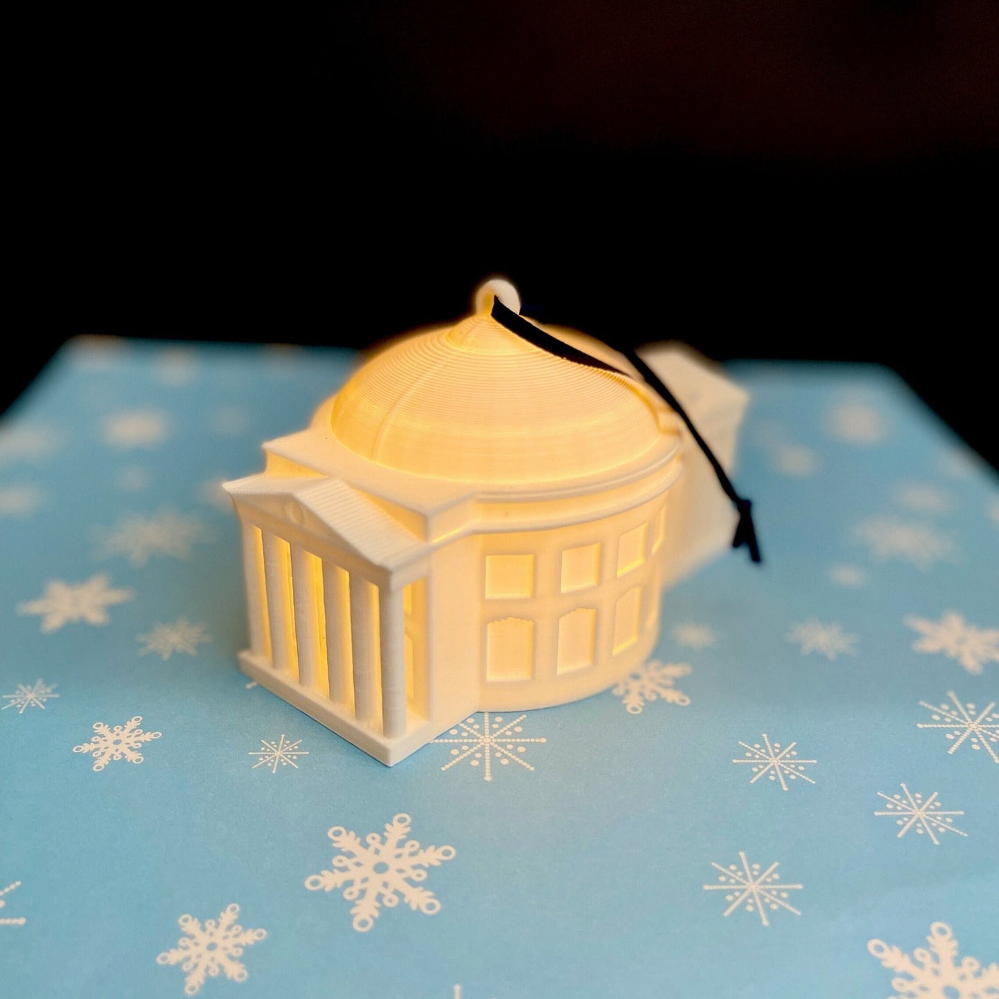 The lighted UVA rotunda ornament, shown against a blue background.